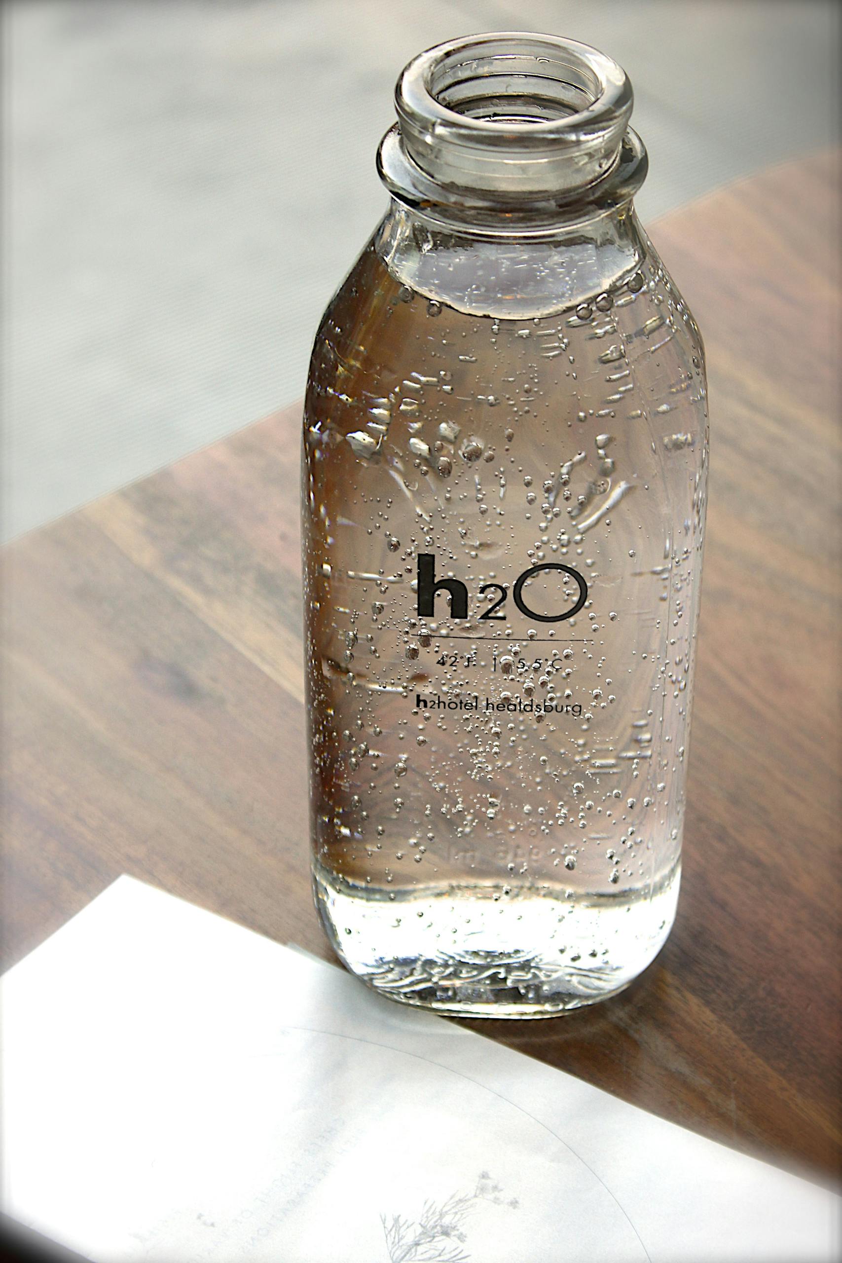 Close-up of a sparkling water bottle on a wooden table, refreshing and hydrating.